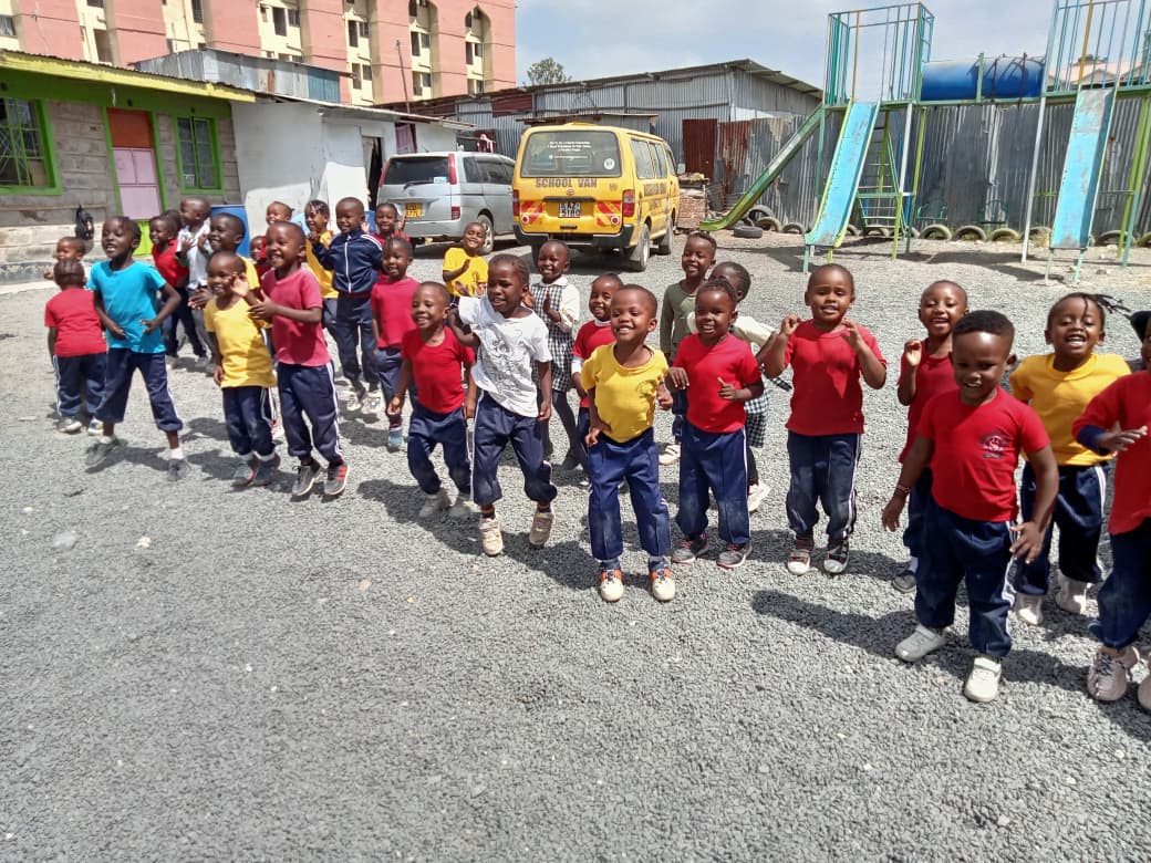 Pre-primary learners cheering in the school playground